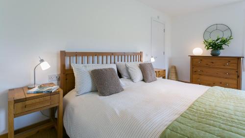 a bedroom with a bed and a table with a lamp at Bath Cottage in Caernarfon
