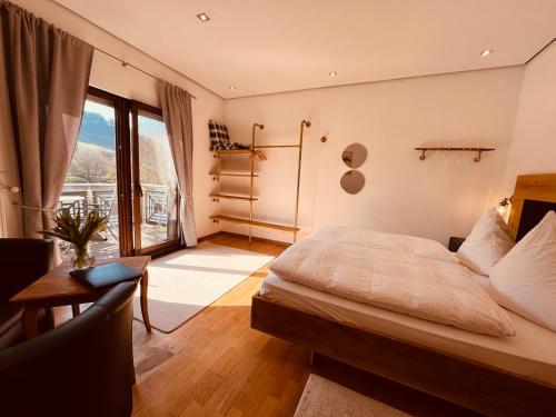 a bedroom with a bed and a table and a window at Hotel zum Anker in Detzem