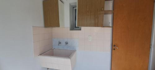 a kitchen with white tiled counters and a sink at Depto 75m 2 dormitorios Frente al Parque Central con Cochera en el Centro denMendoza in Mendoza