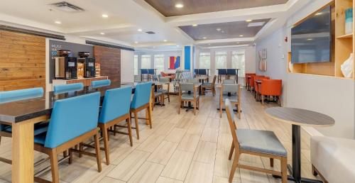 a dining room with blue chairs and tables in a restaurant at Holiday Inn Express Hotel & Suites Medford-Central Point by IHG in Central Point