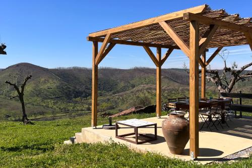 a wooden pavilion with a table and a vase at Casa da Vinagra in Pé da Serra