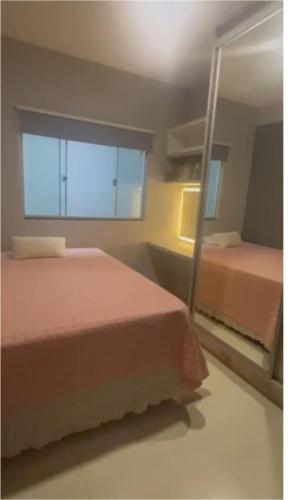 a bedroom with two beds and a large window at Casa Baviera -MOTO GP GOIANIA in Aparecida de Goiânia