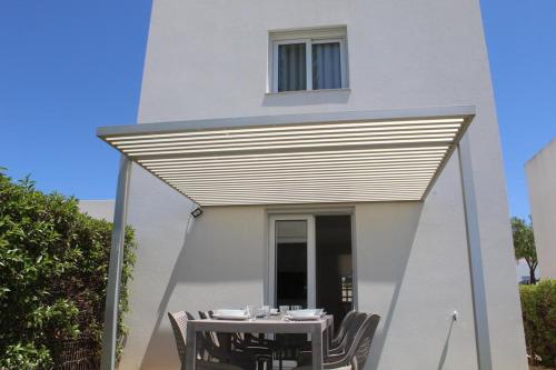 a table and chairs under awning in front of a building at Quinta dos Crastos Pool House in Porches