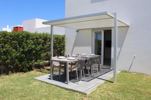 a table and chairs under a canopy on a patio at Quinta dos Crastos Pool House in Porches