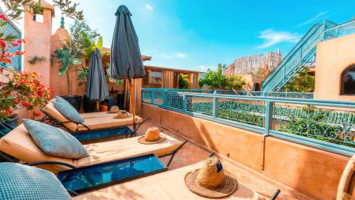 ein Balkon mit Tischen und Sonnenschirmen an einem Gebäude in der Unterkunft Riad Dama & Spa in Marrakesch