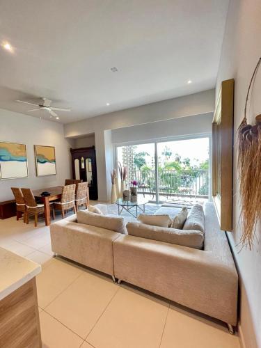 a living room with a large couch and a dining room at New 2 bedroom rooftop condo in Nuevo Vallarta