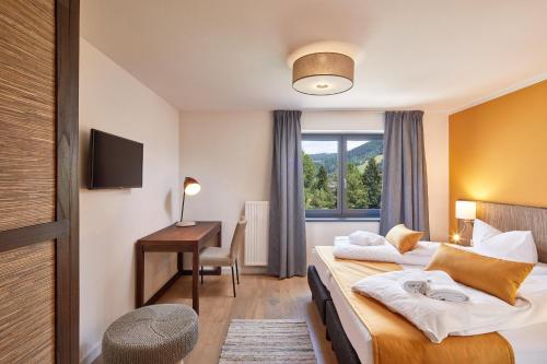 a hotel room with two beds and a desk at Kristall Plaza in Niederau