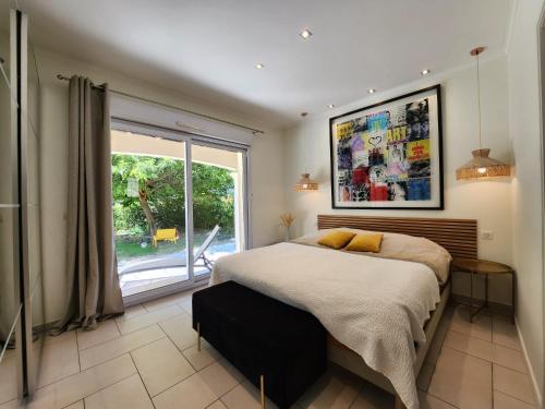 a bedroom with a bed and a large window at happyfew villa laghet in La Trinité