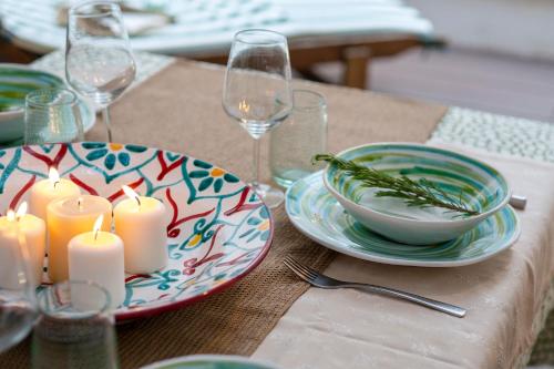 a table with a plate with candles and wine glasses at Dimora Sardaro Suites by BarbarHouse in Monopoli