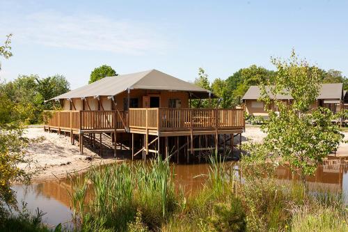 a large building with a roof on a beach at Vakantiepark Sallandshoeve in Nieuw-Heeten