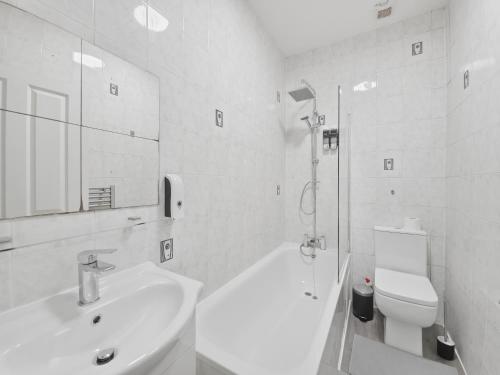 a white bathroom with a sink and a toilet at Urban retreat near the station in London
