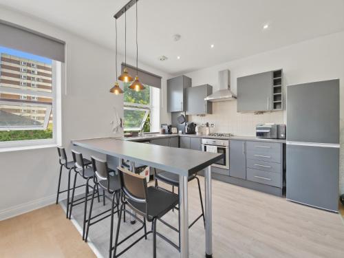 a kitchen with a table and chairs in a room at Urban retreat near the station in London