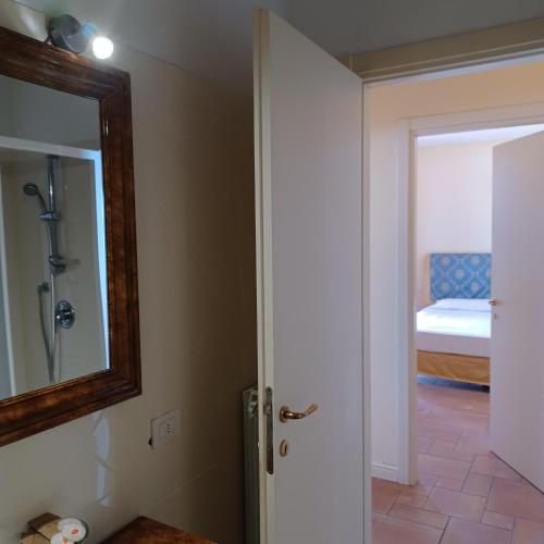 a bathroom with a mirror and a bedroom with a bed at Residence Il Vigneto - Casa Sopralago in Oggebbio