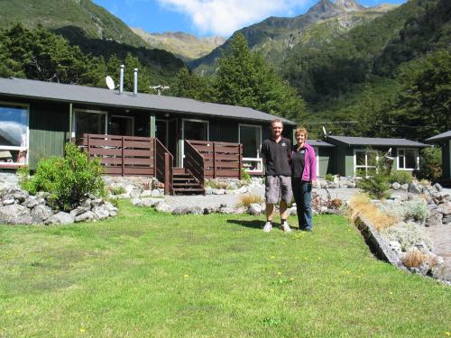 a man and a woman standing in front of a building at Arthur's Pass Alpine Motel in Arthur's Pass