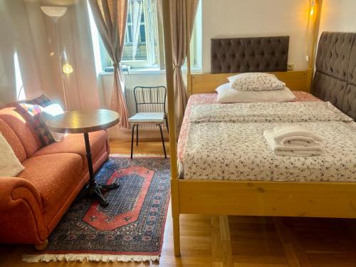 a bedroom with a bed and a table and a couch at Apartments Emma in Prague