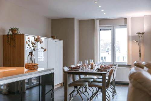 a dining room with a table and chairs and a window at Casiola - Spacious apartment with private car park in Blankenberge