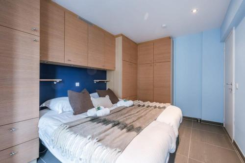 a large bed in a room with wooden cabinets at Casiola - Spacious apartment with private car park in Blankenberge