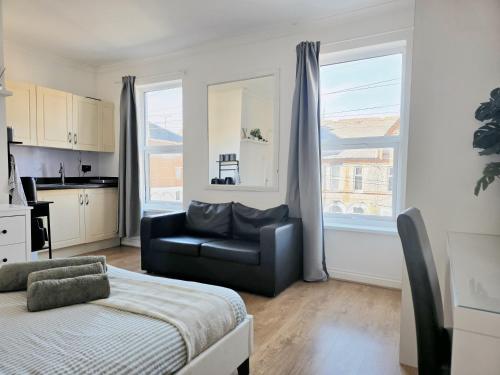 a living room with a couch and a chair in front of a window at Studios & Ensuite Doubles - Central RG1 - Oracle - Station & Hospital in Reading
