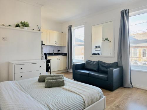 a bedroom with a bed and a black chair at Studios & Ensuite Doubles - Central RG1 - Oracle - Station & Hospital in Reading