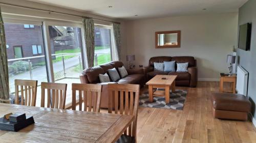 a living room with a couch and a table at Peaceful relaxing home with leisure in Saint Columb Major