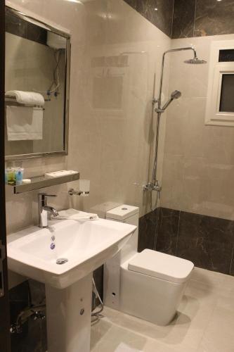 a bathroom with a sink and a toilet and a shower at Nital Furnished Apartment in Riyadh
