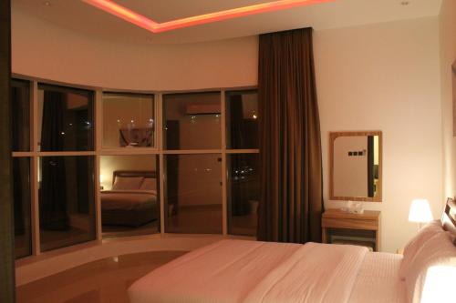 a hotel room with a bed and a large window at Nital Furnished Apartment in Riyadh