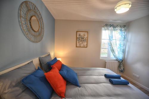 a bedroom with a bed with blue and orange pillows at Fleur des Vents in Saint-Flour