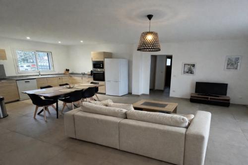 a living room with a couch and a table and a kitchen at Résidence A Traggina in Prunelli-di-Fiumorbo