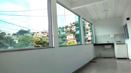 an empty room with large windows in a building at Apartamento Estilo Moderno in Belo Horizonte