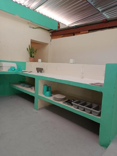 a room with a green counter with plates on it at Turquesa Bacalar Centro in Bacalar