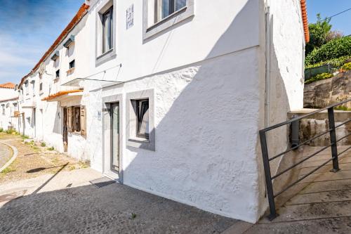 a white building with a gate on a street at Douro View Charming Apartment Duplex in Valbom