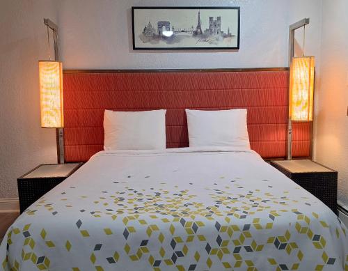 a bedroom with a large bed with two lamps at Southington Motor Lodge in Southington