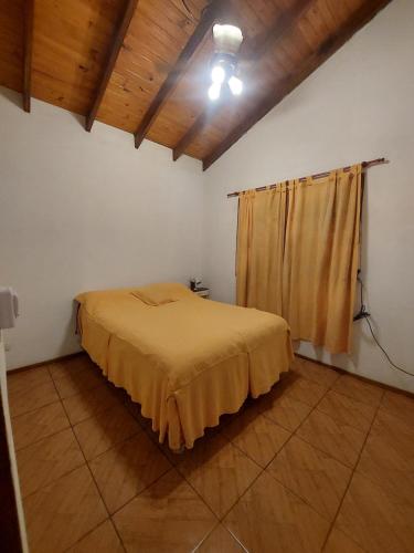a bedroom with a bed in a room with wooden ceilings at Cabaña la Gabita in Villa Ciudad Parque