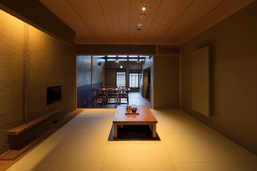 a room with a table in the middle of a room at Masarigusa Machiya House in Kyoto