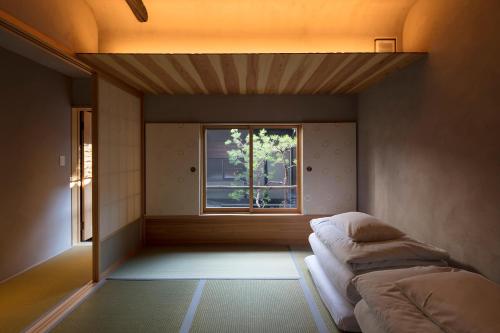 a small room with a bed and a window at Masarigusa Machiya House in Kyoto