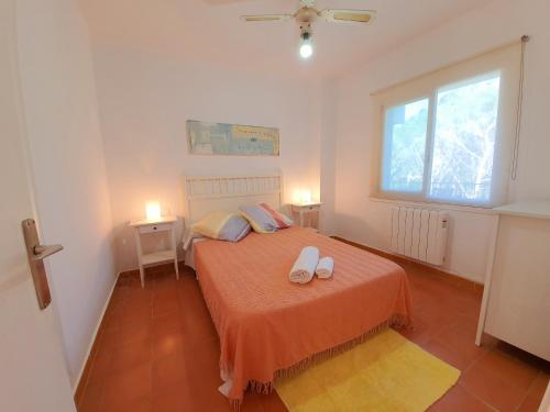 a bedroom with a bed with two shoes on it at APARTAMENTO PALS BEACH-3 in Pals