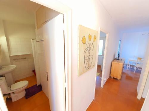a bathroom with a toilet and a painting on the door at APARTAMENTO PALS BEACH-3 in Pals