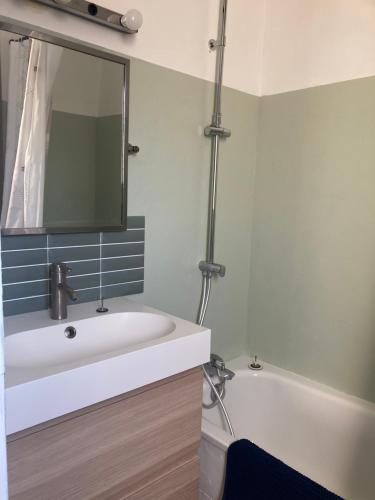 a bathroom with a sink and a tub and a mirror at Villa Rose Suite et chambres chez l'habitant in Montpellier
