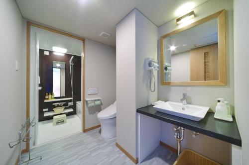 焼津市にあるホテルアンビア松風閣のバスルーム(洗面台、トイレ、鏡付)