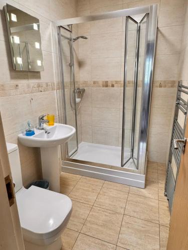 a bathroom with a shower and a toilet and a sink at The Shelbourne in Southport