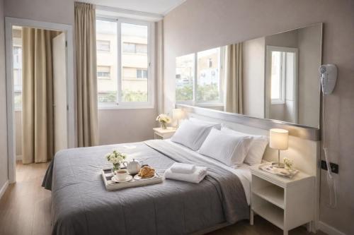 a bedroom with a bed with a tray of food on it at Aparthotel Montcada in Montcada i Reixac