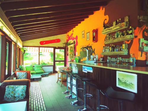 a bar in a restaurant with an orange wall at Surf House Gerra in San Vicente de la Barquera