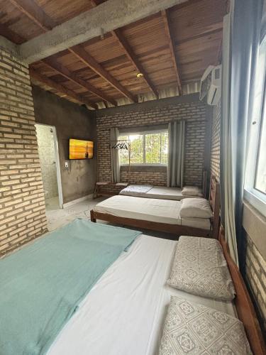 a bedroom with two beds and a window at Chalé Florada d' Serra in Chapada dos Guimarães