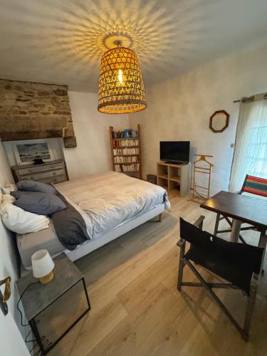 a bedroom with a bed and a chandelier at Charming house in an old rectory PMR in Tréguier