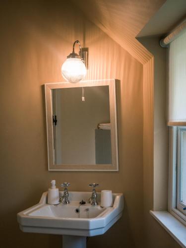 a bathroom with a sink and a mirror at Killee Cottage in Mitchelstown