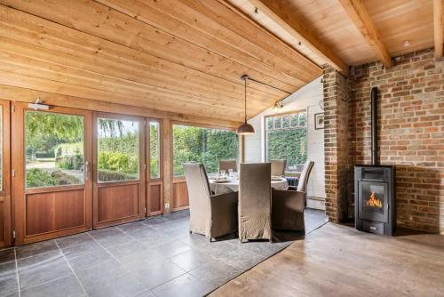 a dining room with a table and a fireplace at Casiola - Authentic vacation home 'De Blauwe Kroon' in Oostkamp