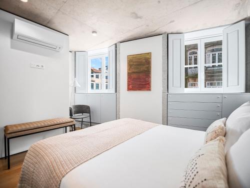 a white bedroom with a bed and two windows at Padrão 319 - Touristic Apartments in Porto