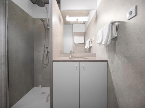 a white bathroom with a sink and a shower at Padrão 319 - Touristic Apartments in Porto