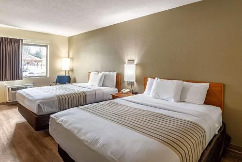 a hotel room with two beds and a window at Budget Inn in Ithaca