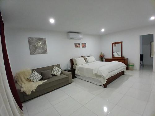 a bedroom with a bed and a couch in it at Cayenas Apartament in Willemstad